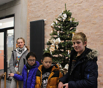 Vier Kinder vor einem Weihnachtsbaum