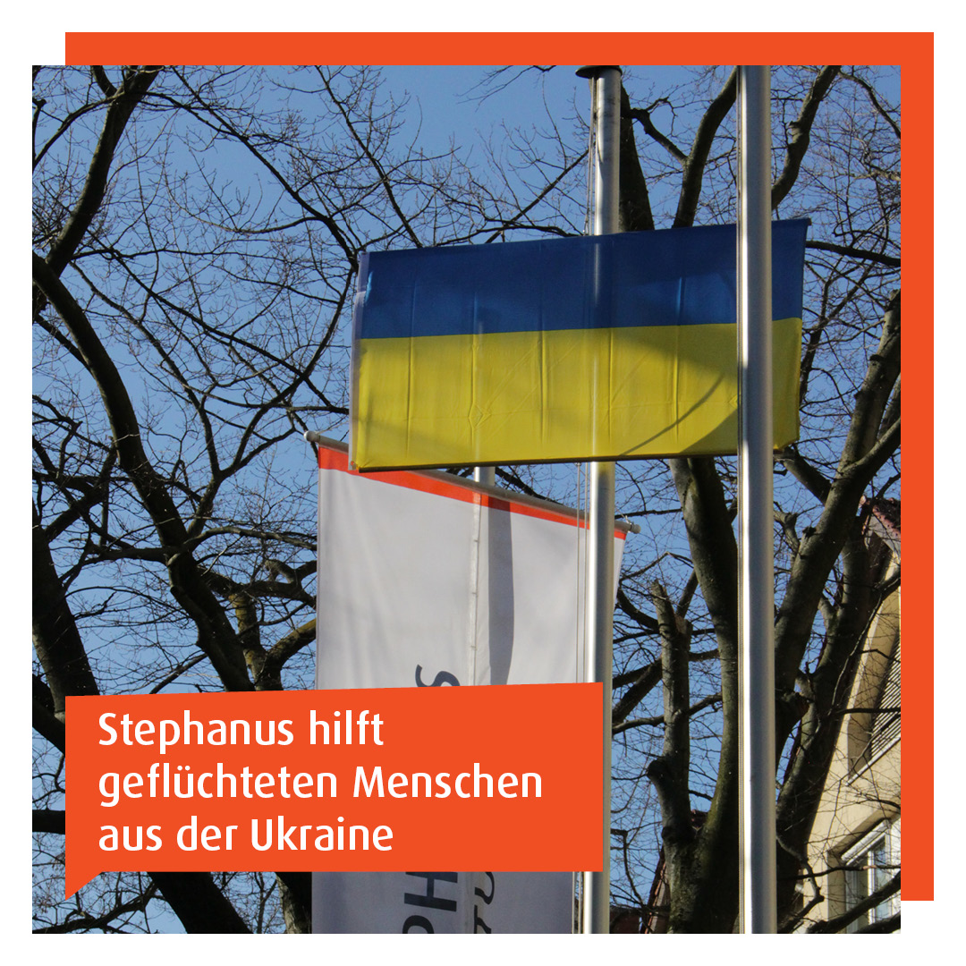 Ukraine-Flagge im Vordergrund, dahinter Stephanus-Flagge vor blauem Himmel