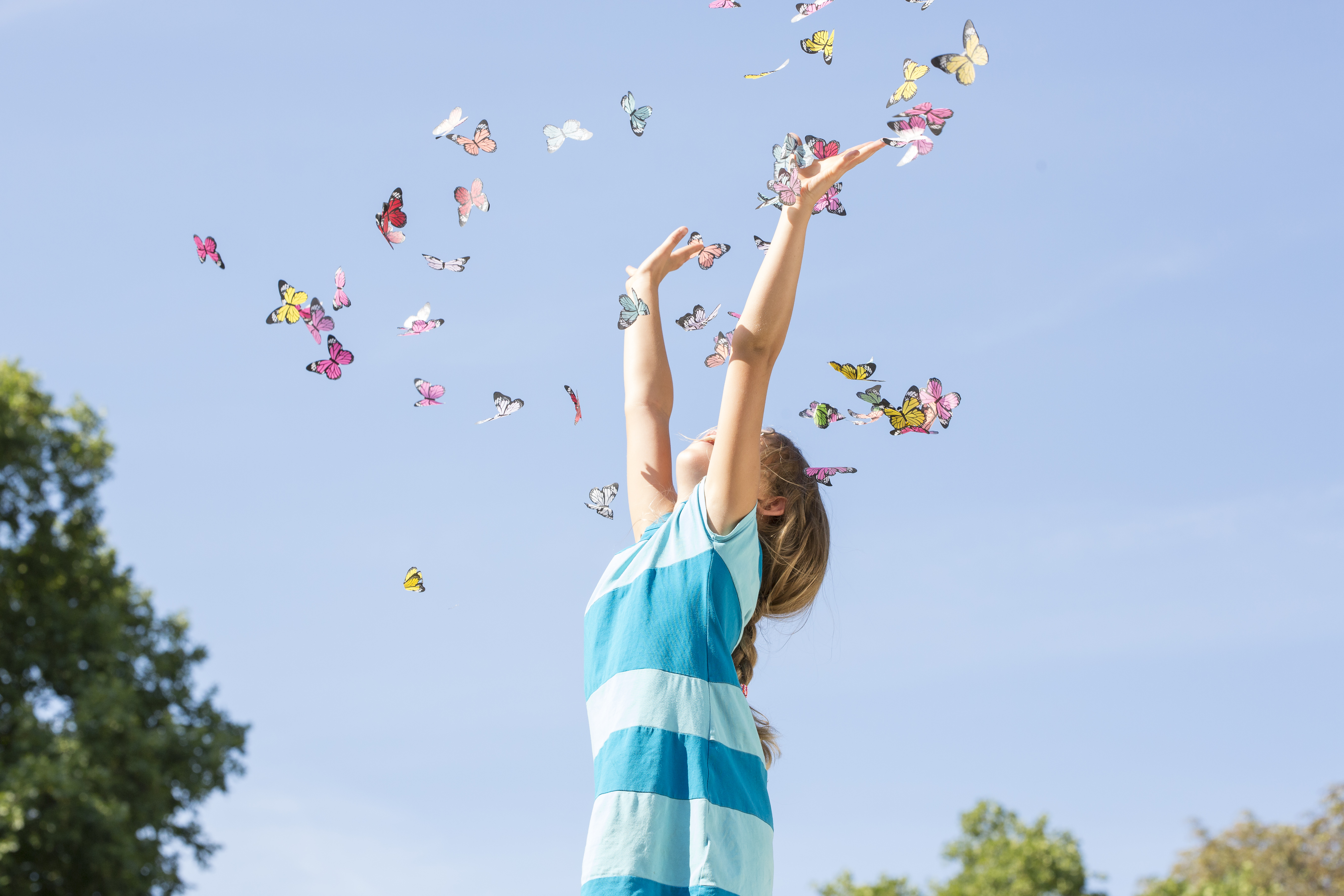Kind wirft Schmetterlinge in die Luft