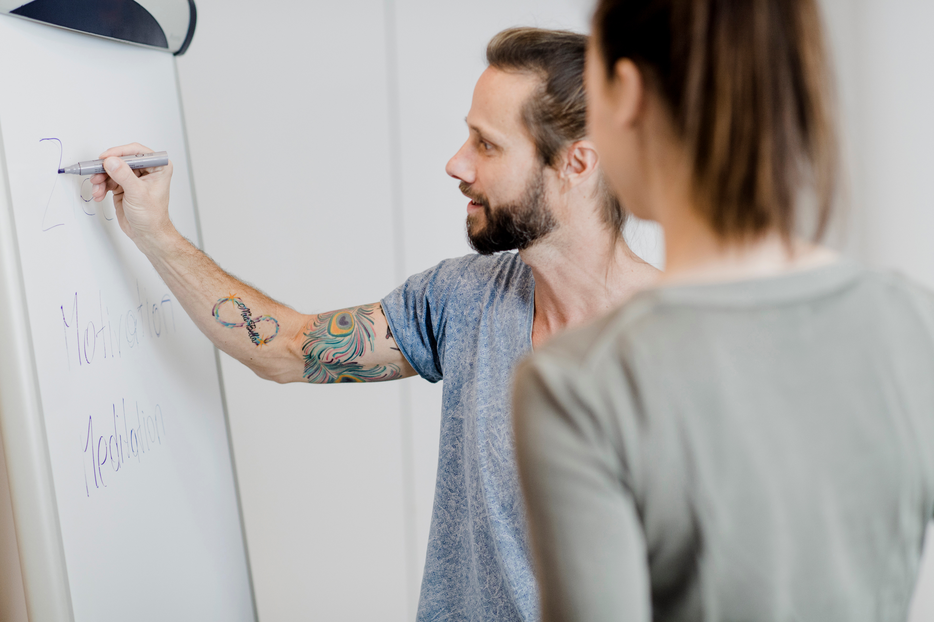 Ein Mann skizziert an einem Flipchart mit einem Stift einen Weg.