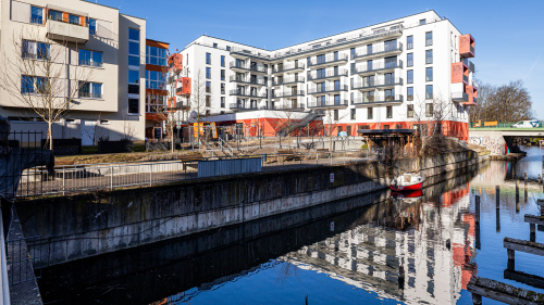 Das Schloßberg-Quartier spiegelt sich im Wasser