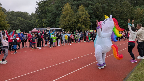 Ein Einhorn-Maskottchen leitet die Erwärmung an und springt dabei in die Luft.