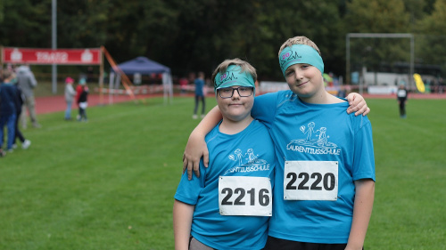 Die Schüler Niklas und Lars tragen Sportshirts der Laurentiusschule und stehen im Jahn-Stadion.