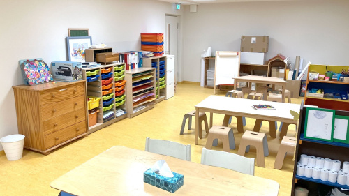 Kleine Tische und Stühle sowie Regale mit buntem Material