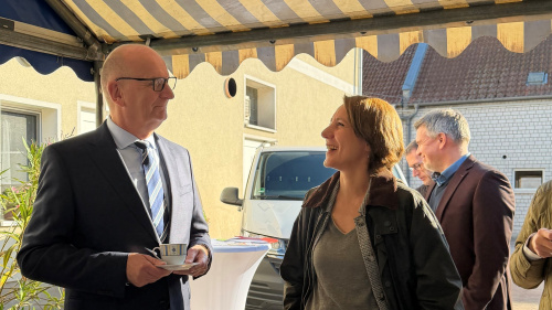 Zwei Personen stehen unter einer Markise und lachen