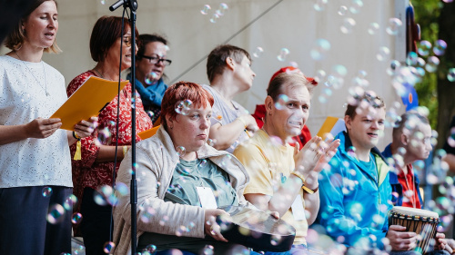 Musikgruppe auf Bühne mit Instrumenten, Seifenblasen schweben durch das Bild.