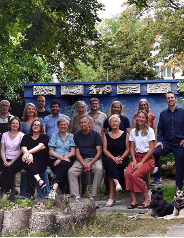 Ein Gruppenfoto von Lehrerinnen und Lehrer und zwei Hunden des Oberlin-Seminars im Grünen