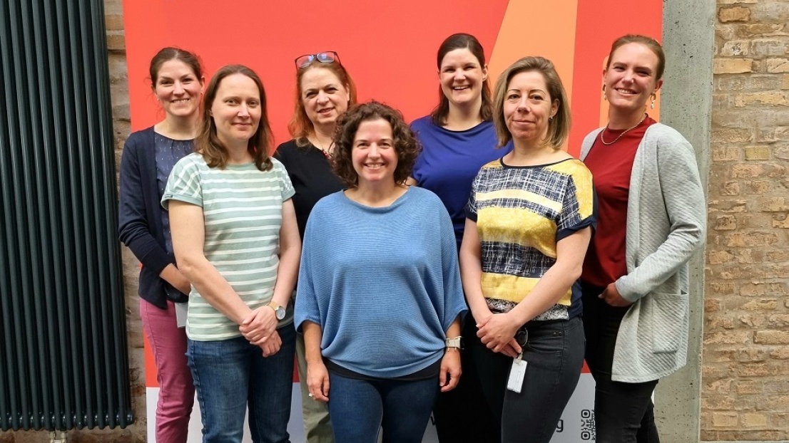 Eine Gruppe von Frauen steht fröhlich lächelnd im Flur der Stephanus-Zentrale in Berlin Weißensee.