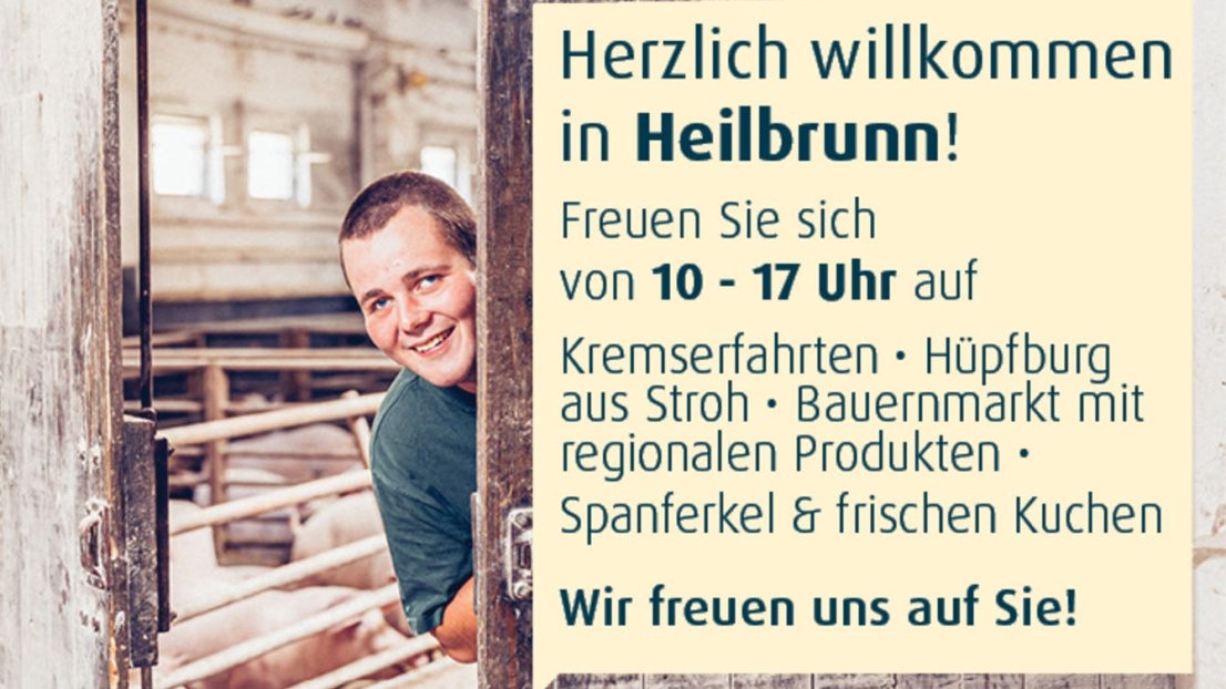 Plakat für die Landpartie. Ein Foto eines jungen Mannes, der hinter einer Stalltür lächelnd zur Kamera schaut. Im Hintergrund sieht man einen Schweinestall.