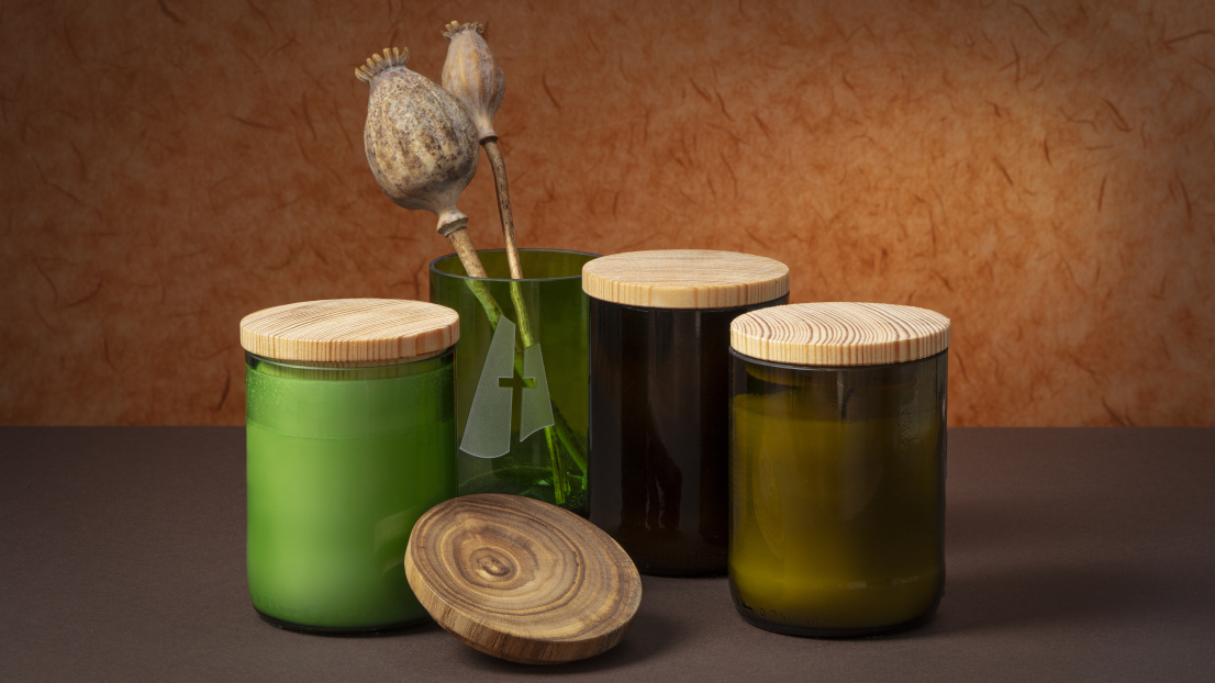 Grüne und braune Weinflaschen wurden halbiert und mit Kerzenwachs gefüllt. Ein passender Holzdeckel macht aus der Kerze ein hübsches Geschenk.