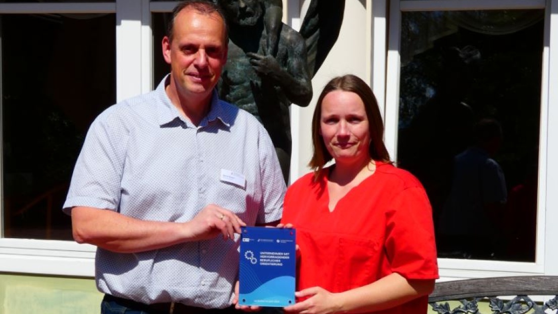  Bernd Bartels und Mareike Vierjahn halten eine Plakette in der Hand und stehen vor dem Gebäude des Seniorenzentrums Christophorus