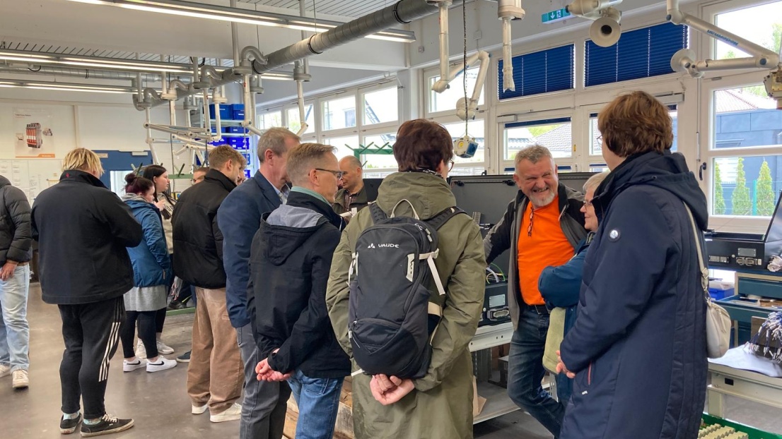 Menschen schauen in der Stephanus-Werkstatt bei der Produktion zu.