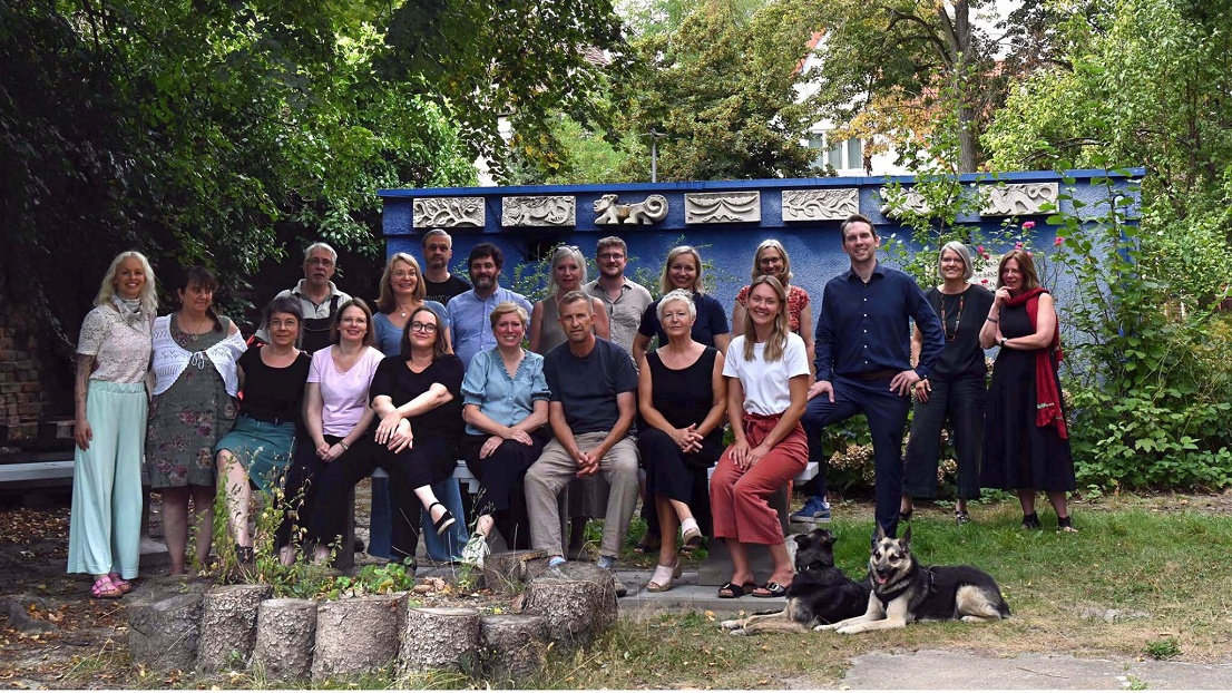Ein Gruppenfoto von Lehrerinnen und Lehrer und zwei Hunden des Oberlin-Seminars im Grünen
