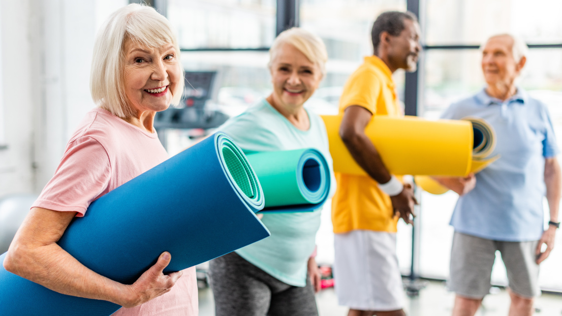Seniorinnen und Senioren mit Gymnastikmatten in einem Bewegungsangebot.