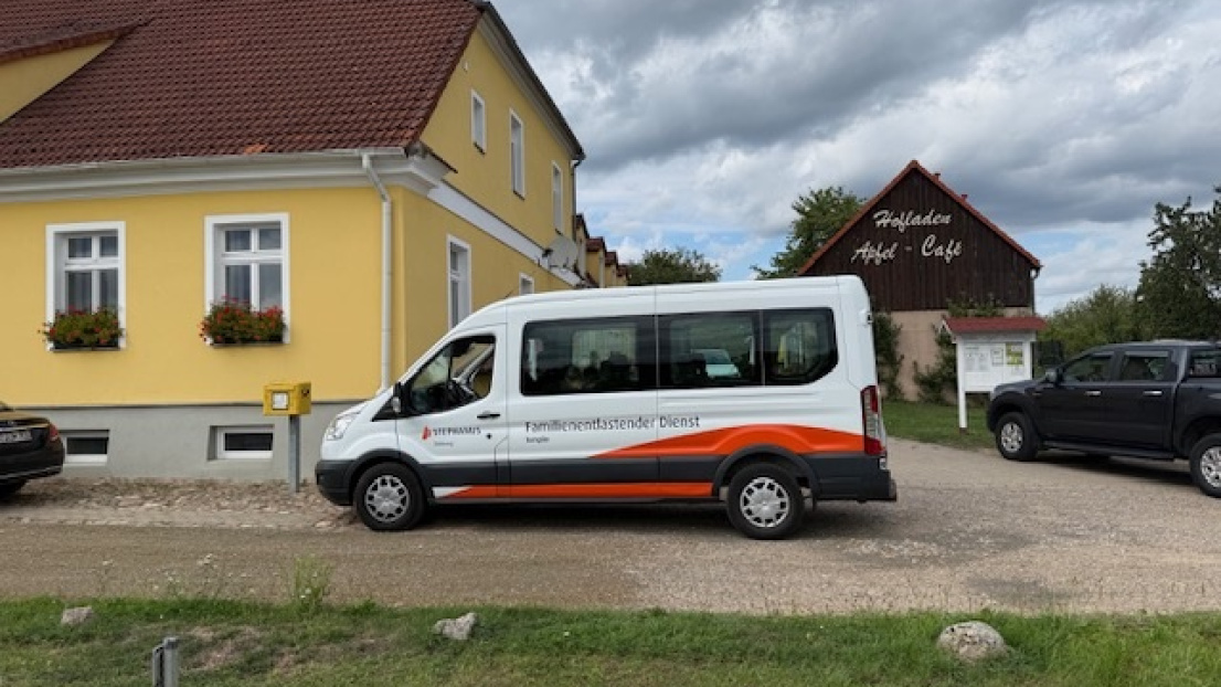 Ein Auto von Stephanus Familienentlasteten Dienst steht neben dem Hofladen und Apfel-Café