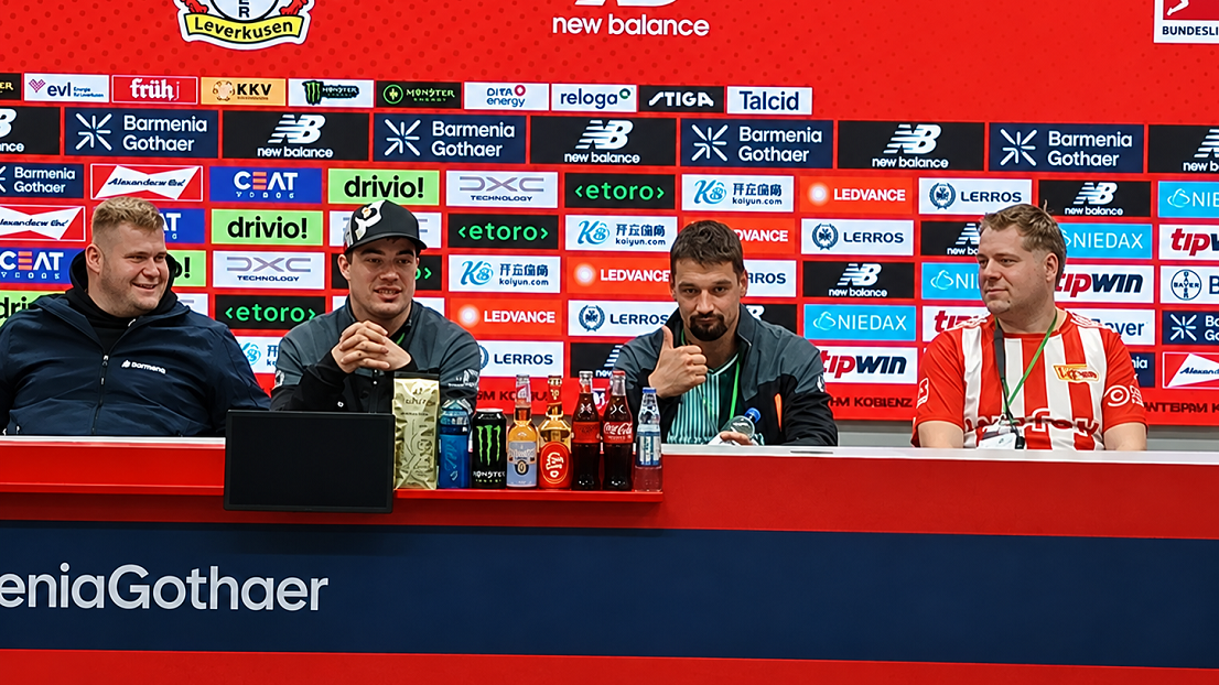 Vier Männer sitzen am Tisch im Presseraum. Ein Mann von Stephanus zeigt den Daumen nach oben.