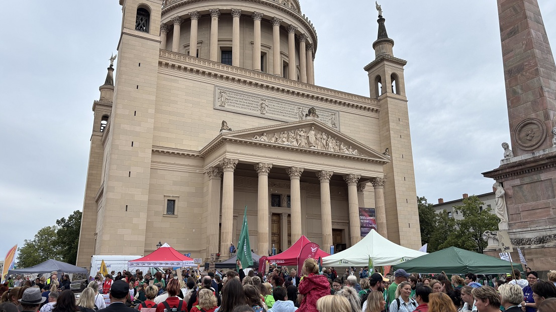 Viele Menschen stehen an der St. Nikolaikirche und unterhalten sich mit einander