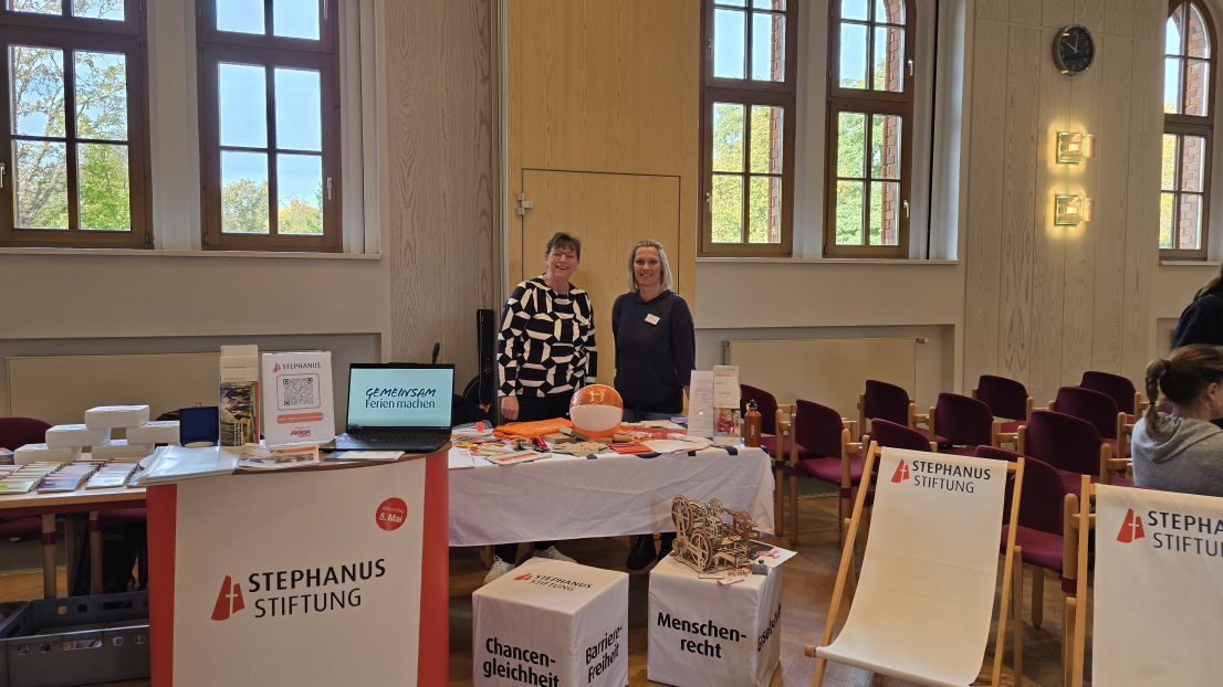 Stephanie Thiedig, Projektkoordinatorin "ferien-inklusiv" und Silke Titze, Projektkoordinatorin "Ambulante Wohnschule" an ihrem Informationsstand im Plenarsaal des Landkreises Uckermark, Prenzlau