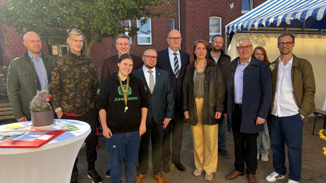 Die Teilnehmenden des Termins stehen vor einem roten Backsteingebäude für ein Gruppenfoto zusammen.