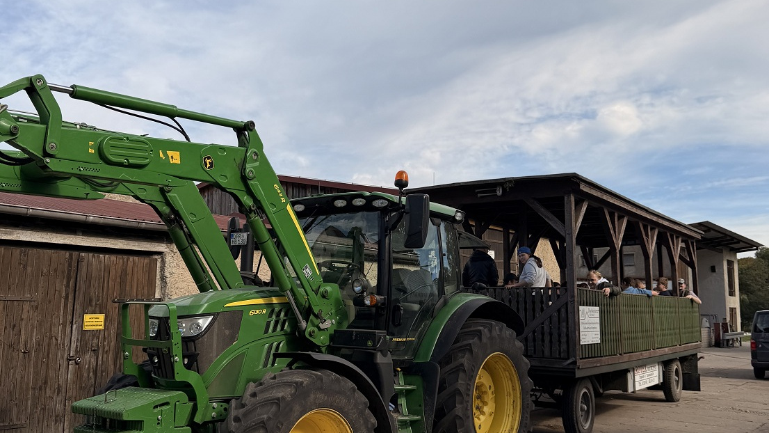 Ein Traktor mit Kremser. Im Kremser sitzen Bewohner und Beschäftigte