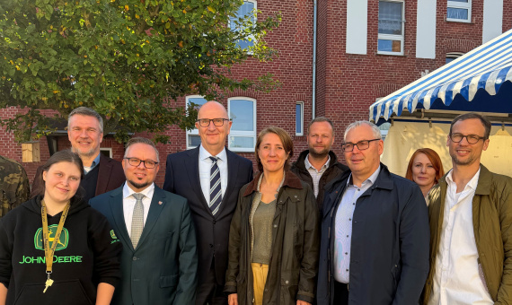 Die Teilnehmenden des Termins stehen vor einem roten Backsteingebäude für ein Gruppenfoto zusammen. 